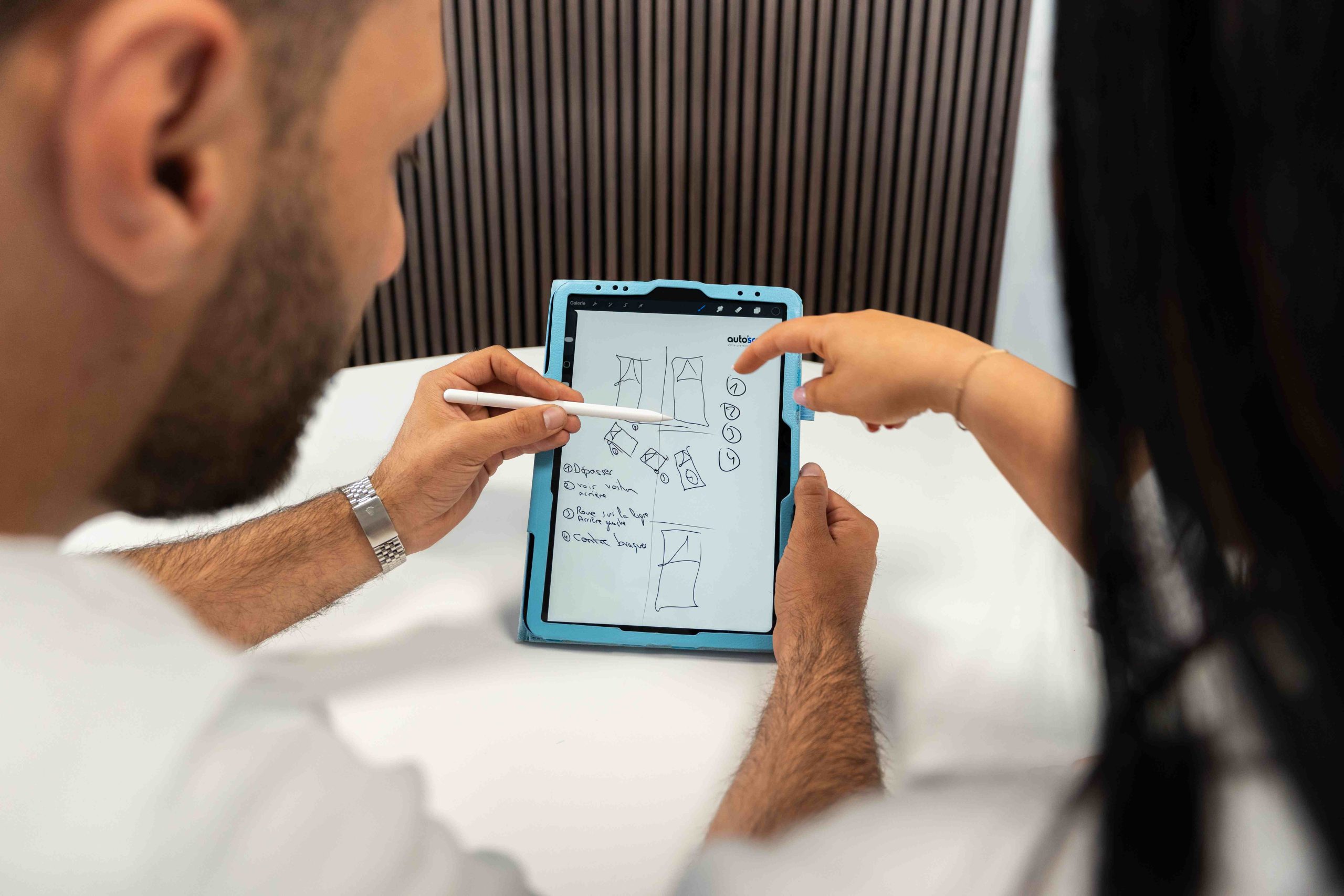 Moniteur et élève auto'scool révisant les manœuvres officielles de l'examen pratique de conduite sur une tablette